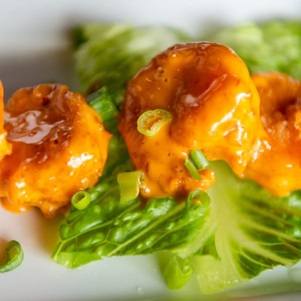 Christopher's Steakhouse and Seafood's crispy shrimp appetizer, coated in orange sauce and garnished with green onions.