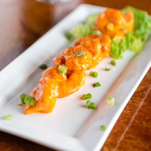 Christopher's Steakhouse and Seafood's bang bang shrimp appetizer, garnished with green onions and lettuce.