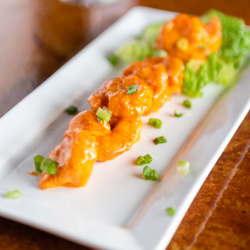 Christopher's Steakhouse and Seafood's bang bang shrimp appetizer, garnished with green onions and lettuce.